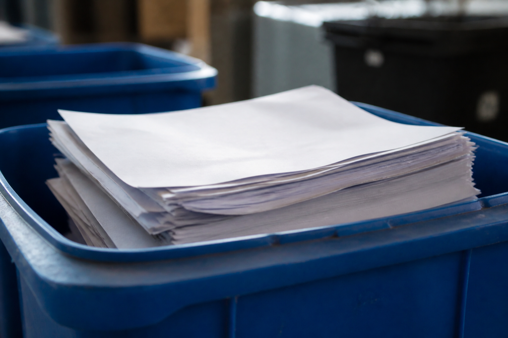Feuilles papier imprimes empilees dans bac de tri