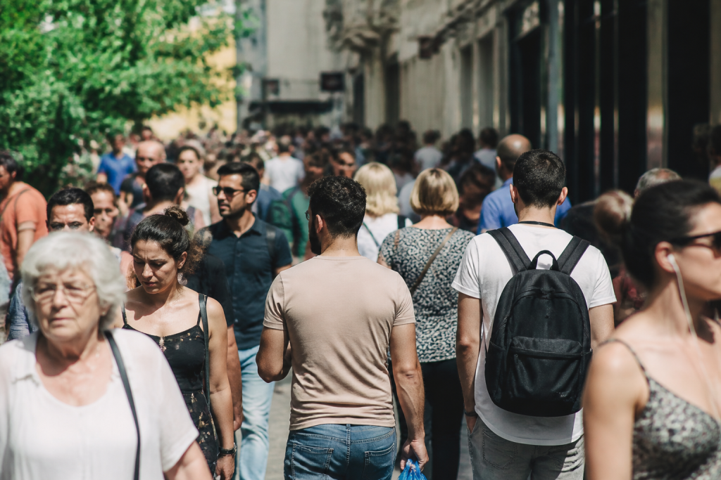 Foule diverse marchant dans une rue commerciale ensoleillee