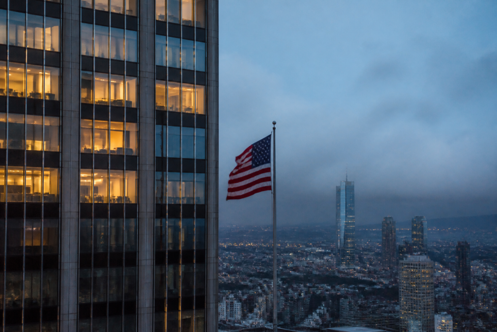 Gratte-ciel illumines et drapeau flottant au crepuscule